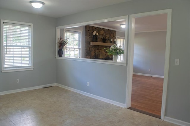 empty room with crown molding, a wealth of natural light, and light hardwood / wood-style flooring