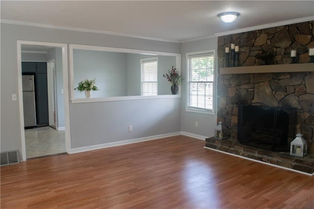 unfurnished living room with a fireplace, wood-type flooring, and ornamental molding