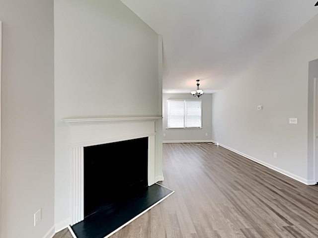 365 Wesley Mill Pl, Villa Rica, GA 30180 - unfurnished living room featuring wood finished floors, a chandelier, and a fireplace with raised hearth