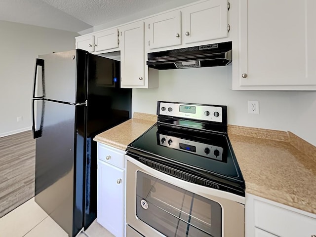 365 Wesley Mill Pl, Villa Rica, GA 30180 - kitchen with electric range, under cabinet range hood, freestanding refrigerator, light countertops, and white cabinets