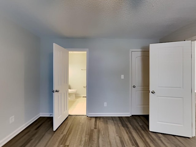 365 Wesley Mill Pl, Villa Rica, GA 30180 - unfurnished bedroom featuring wood finished floors, a textured ceiling, and ensuite bath