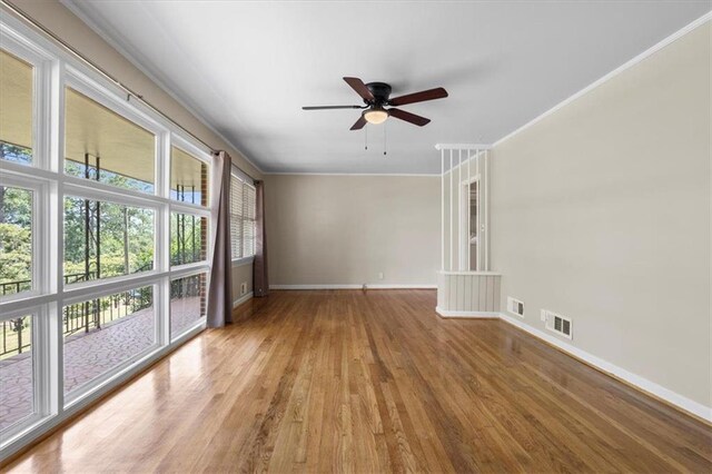 empty room with hardwood / wood-style flooring, ceiling fan, and crown molding