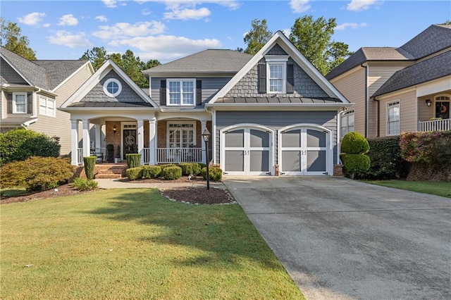 view of front of house with driveway, an attached garage, a porch, a standing seam roof, and metal roof