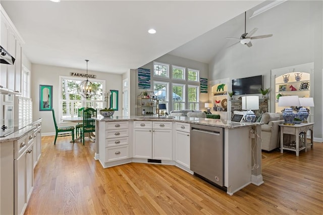 kitchen with open floor plan, stainless steel dishwasher, light wood-type flooring, and plenty of natural light