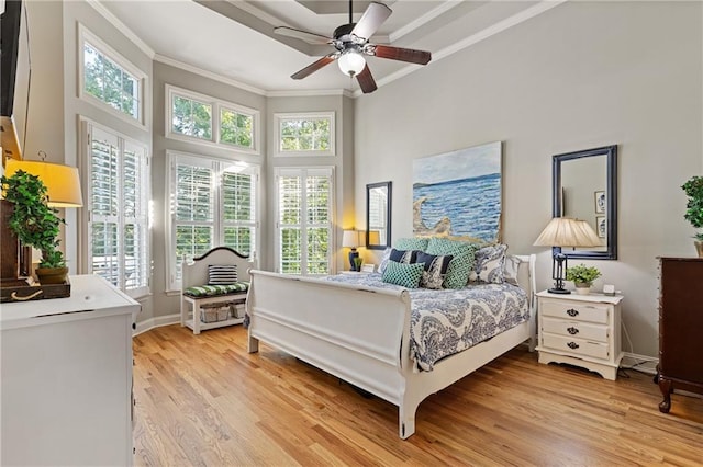 bedroom featuring a towering ceiling, baseboards, ornamental molding, a ceiling fan, and light wood finished floors