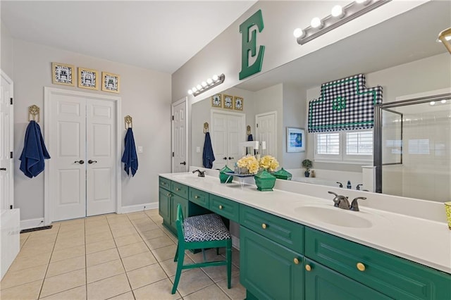 full bath with a sink, double vanity, tile patterned flooring, a shower stall, and a garden tub