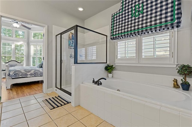 ensuite bathroom with a garden tub, ensuite bathroom, ceiling fan, a shower stall, and tile patterned floors