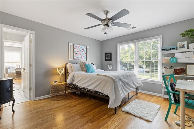 bedroom featuring light wood-style floors, visible vents, and multiple windows