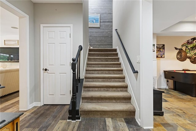 staircase featuring wood finished floors and baseboards
