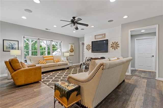 living area featuring visible vents, ceiling fan, baseboards, and dark wood finished floors