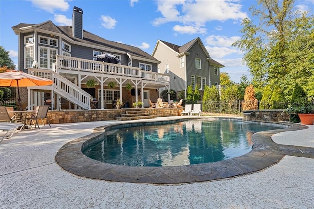 rear view of house with a patio, stairway, an outdoor pool, a deck, and fence