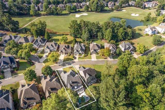 drone / aerial view featuring a residential view, view of golf course, and a water view