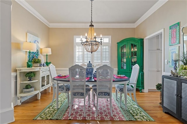 dining space featuring ornamental molding, an inviting chandelier, and wood finished floors