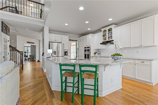 kitchen with a wealth of natural light, light wood-style floors, a sink, and appliances with stainless steel finishes