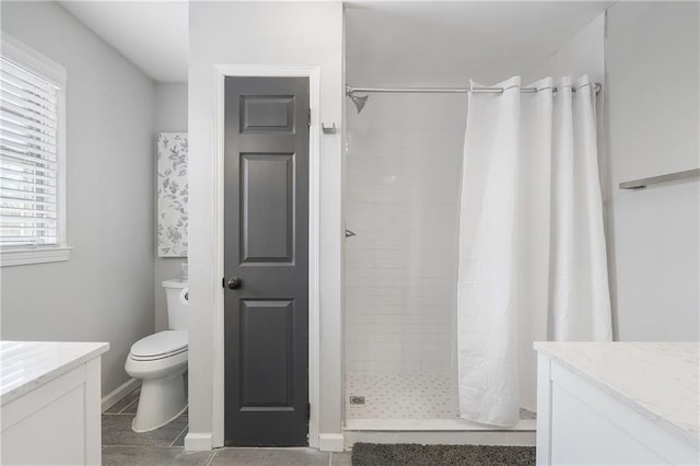 bathroom featuring a shower stall, tile patterned floors, vanity, and toilet