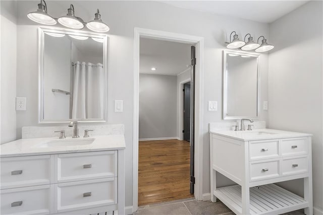 bathroom with a sink, two vanities, and wood finished floors