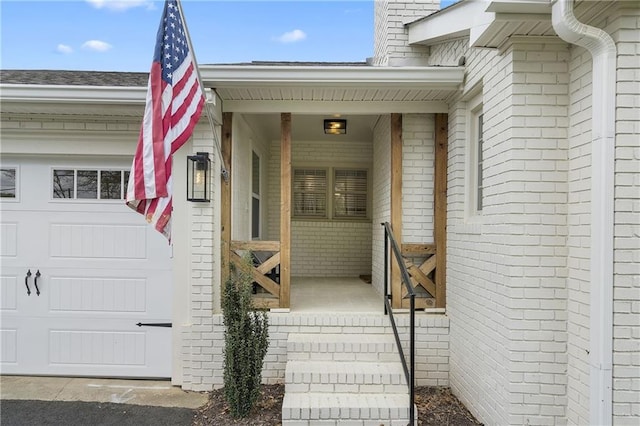 property entrance featuring a garage and brick siding