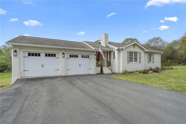ranch-style home with a front lawn, brick siding, an attached garage, a chimney, and driveway