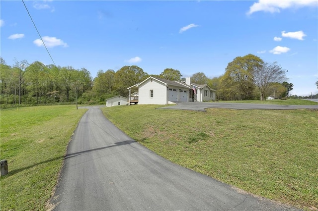 view of front facade with a front yard, an attached garage, and driveway