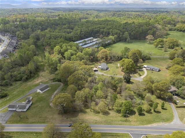 birds eye view of property featuring a forest view