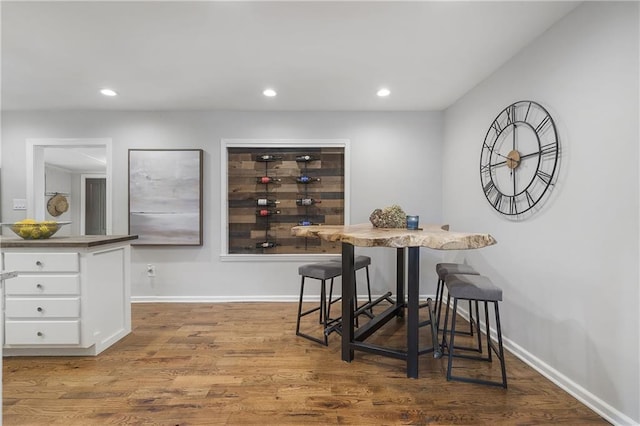 dining room with recessed lighting, baseboards, and wood finished floors