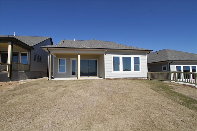 rear view of property with a patio and a shingled roof