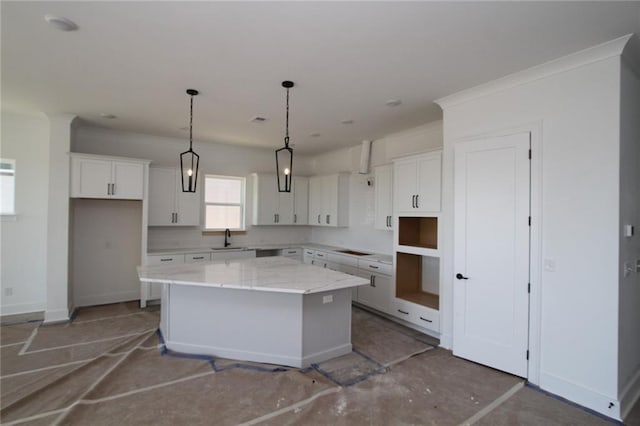 kitchen featuring a sink, a kitchen island, white cabinetry, and baseboards