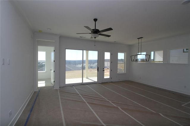 unfurnished room with ceiling fan and baseboards