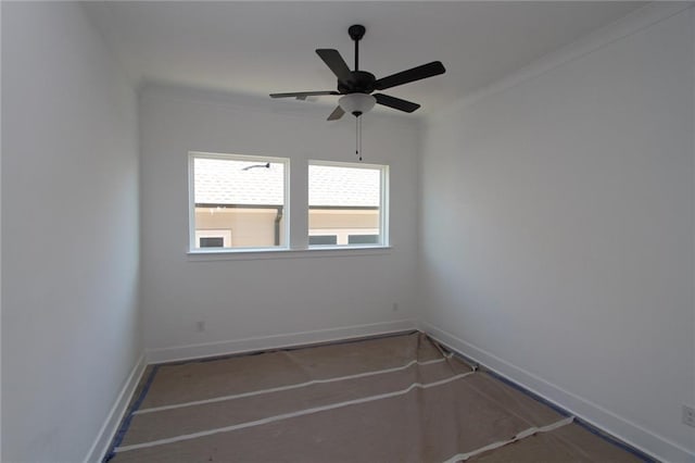 empty room with ornamental molding, baseboards, and a ceiling fan