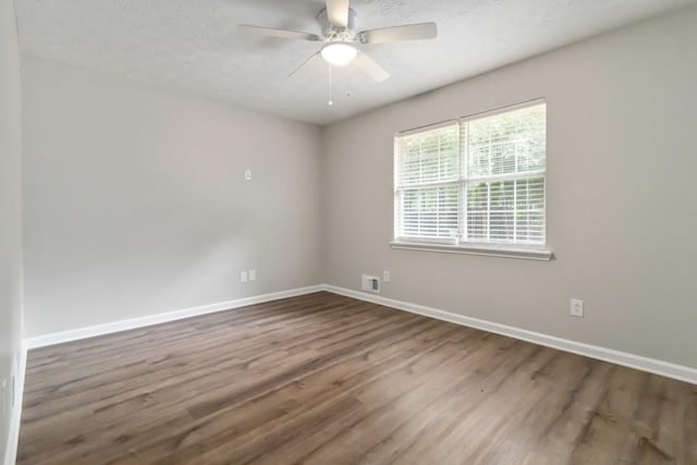 210 Riveredge Way, Mcdonough, GA 30252 - spare room featuring wood finished floors, baseboards, ceiling fan, and a textured ceiling