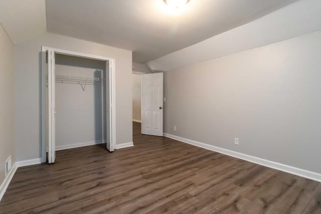 210 Riveredge Way, Mcdonough, GA 30252 - unfurnished bedroom with lofted ceiling, dark wood-style flooring, baseboards, and a closet