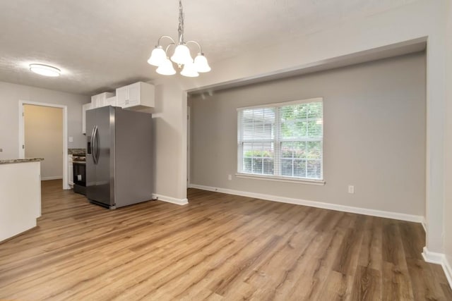 210 Riveredge Way, Mcdonough, GA 30252 - kitchen with appliances with stainless steel finishes, white cabinets, light wood finished floors, a chandelier, and baseboards