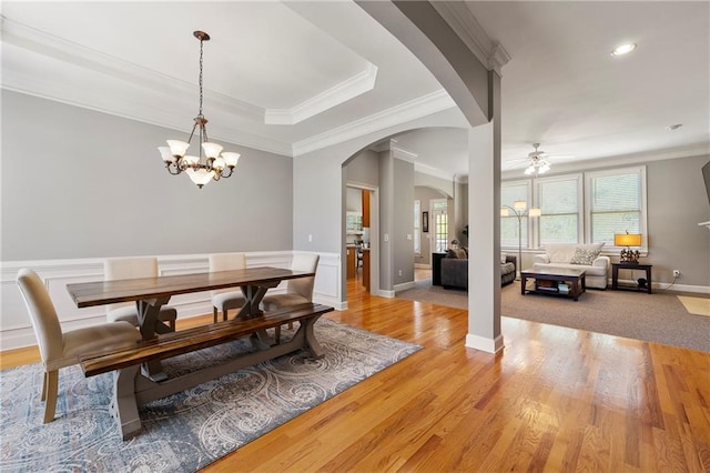 dining room with ceiling fan with notable chandelier, light hardwood / wood-style flooring, and ornamental molding