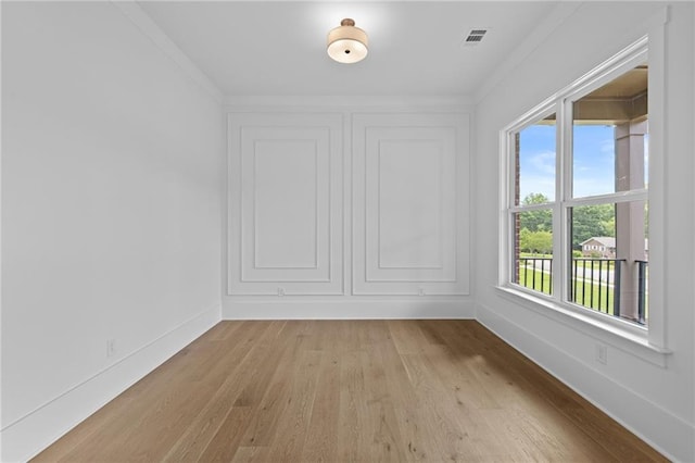 6120 Hutchins Dr, Buford, GA 30518 - spare room featuring light wood-style flooring, baseboards, and crown molding