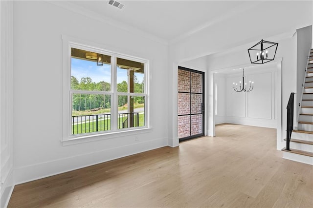 6120 Hutchins Dr, Buford, GA 30518 - unfurnished room with stairway, a chandelier, and light wood-style flooring