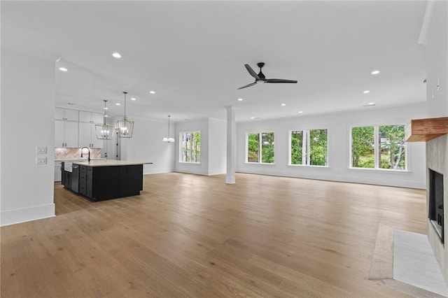 6120 Hutchins Dr, Buford, GA 30518 - unfurnished living room featuring a fireplace with flush hearth, recessed lighting, plenty of natural light, light wood finished floors, and ceiling fan