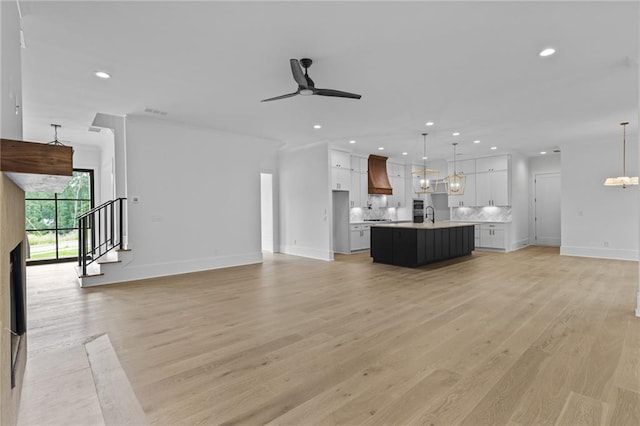 6120 Hutchins Dr, Buford, GA 30518 - unfurnished living room with light wood-type flooring, recessed lighting, ceiling fan, a sink, and baseboards