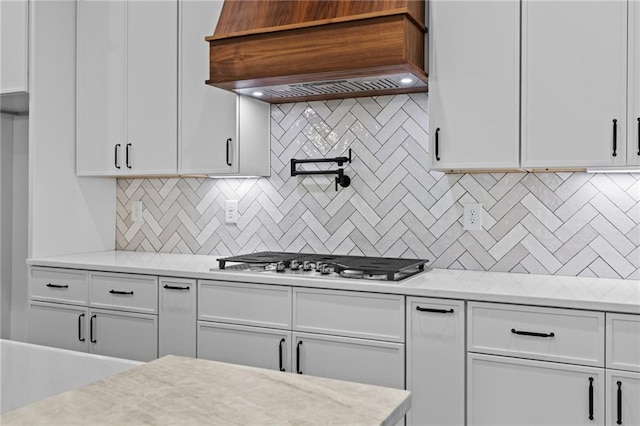 6120 Hutchins Dr, Buford, GA 30518 - kitchen with premium range hood, stainless steel gas stovetop, light countertops, and white cabinets