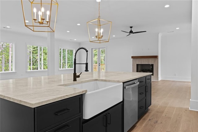 6120 Hutchins Dr, Buford, GA 30518 - kitchen with a sink, dark cabinets, stainless steel dishwasher, open floor plan, and recessed lighting