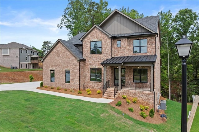 6120 Hutchins Dr, Buford, GA 30518 - craftsman-style home with brick siding, covered porch, a front lawn, and board and batten siding