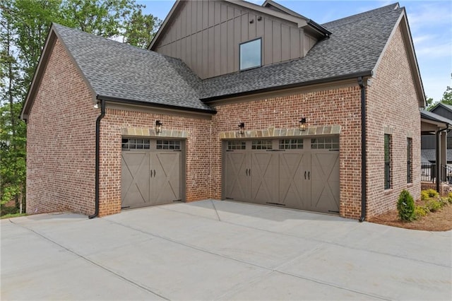 6120 Hutchins Dr, Buford, GA 30518 - view of side of home featuring brick siding, board and batten siding, roof with shingles, and a garage
