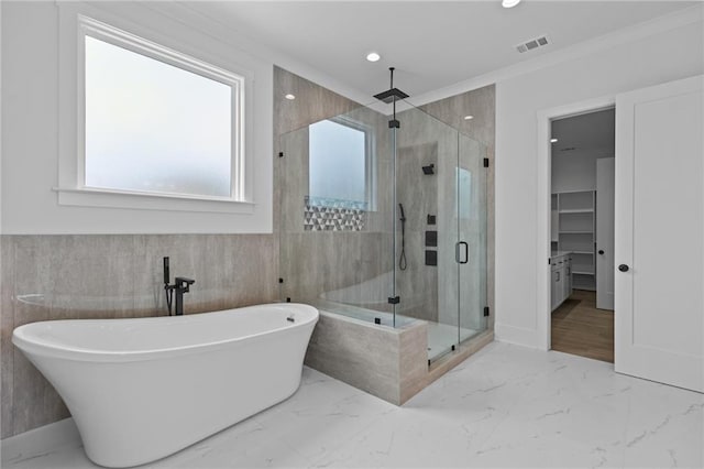 6120 Hutchins Dr, Buford, GA 30518 - bathroom with healthy amount of natural light, a stall shower, a freestanding tub, tile walls, and recessed lighting