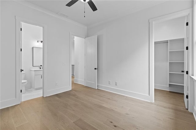 6120 Hutchins Dr, Buford, GA 30518 - unfurnished bedroom with a walk in closet, light wood-style flooring, ensuite bath, baseboards, and ornamental molding