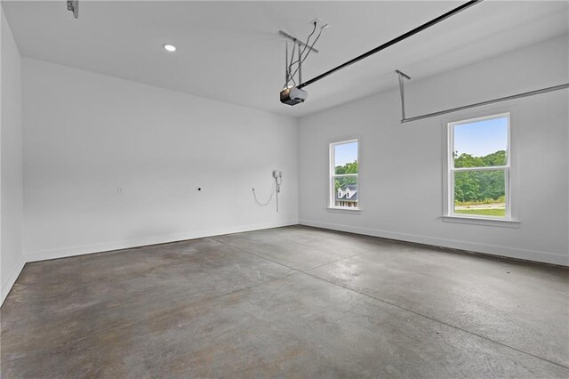 6120 Hutchins Dr, Buford, GA 30518 - garage featuring a garage door opener, baseboards, and recessed lighting