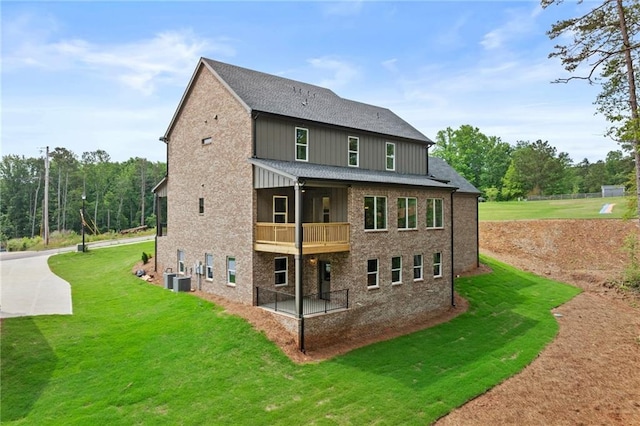 6120 Hutchins Dr, Buford, GA 30518 - rear view of house featuring a lawn, a balcony, central AC unit, and roof with shingles