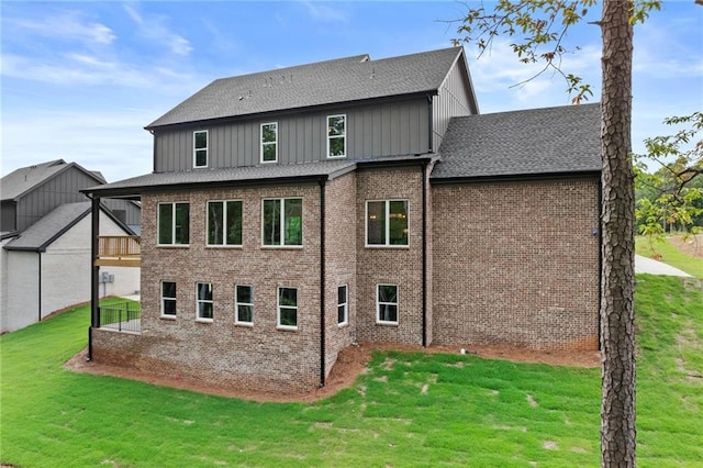 6120 Hutchins Dr, Buford, GA 30518 - rear view of property with a lawn, a shingled roof, board and batten siding, and brick siding
