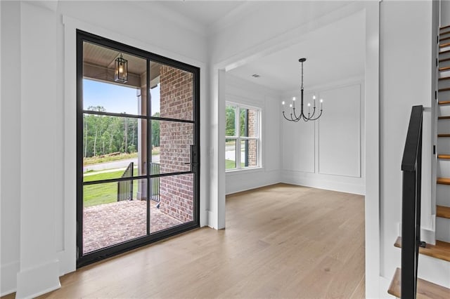 6120 Hutchins Dr, Buford, GA 30518 - unfurnished dining area featuring light wood-style floors, a chandelier, and crown molding