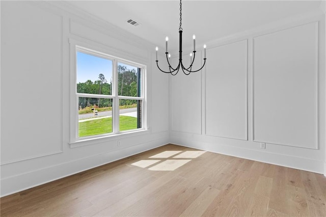 6120 Hutchins Dr, Buford, GA 30518 - unfurnished dining area featuring a chandelier, light wood-type flooring, and a decorative wall