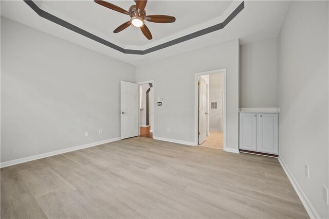6329 Edgewater Cv, Fairburn, GA 30213 - unfurnished bedroom featuring baseboards, ornamental molding, light wood-style flooring, connected bathroom, and a raised ceiling