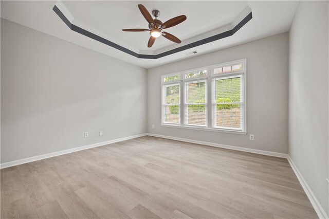 6329 Edgewater Cv, Fairburn, GA 30213 - empty room featuring visible vents, baseboards, a raised ceiling, ceiling fan, and light wood-style flooring